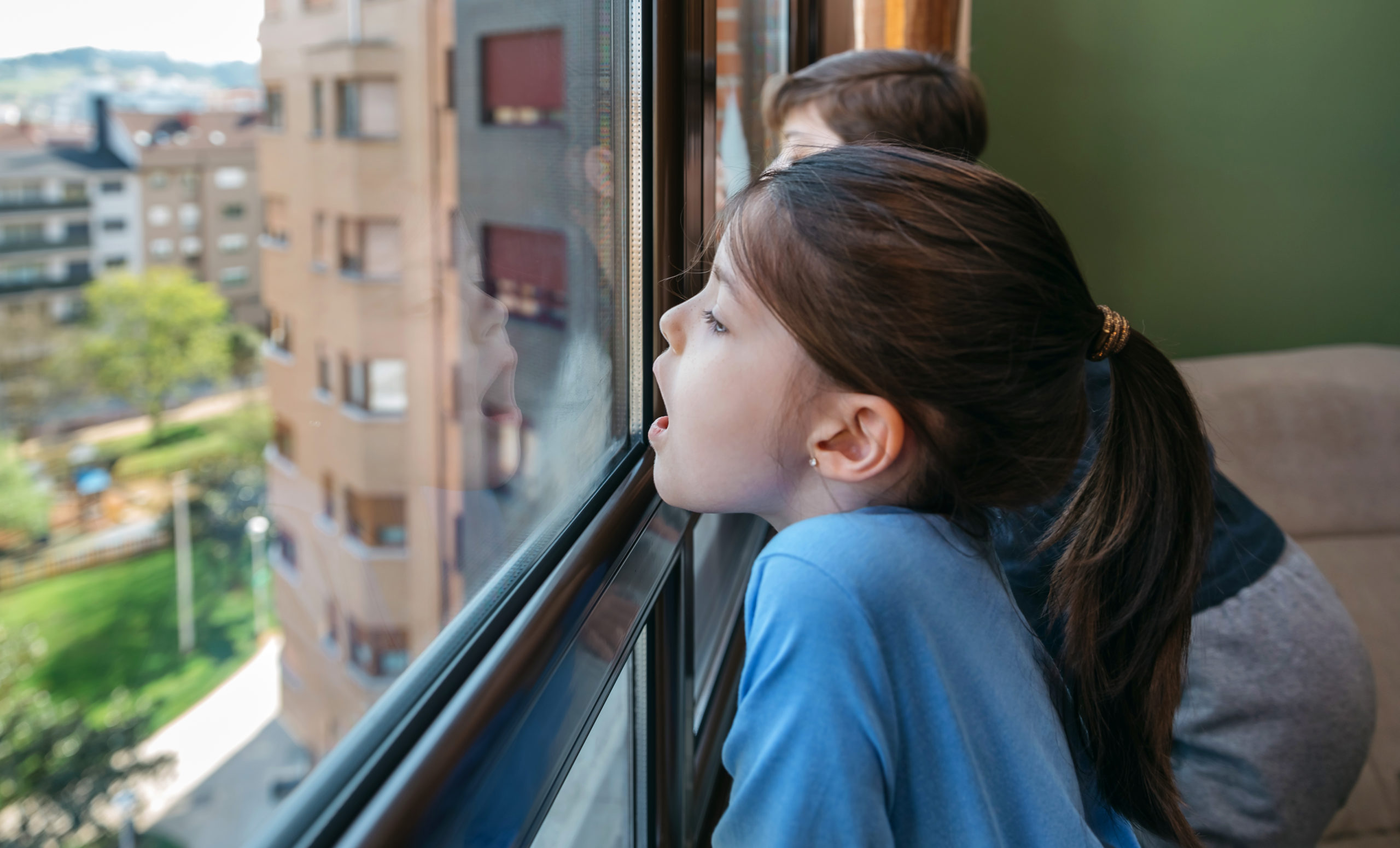 2 Kinder im Hochhaus am Fenster